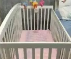 Baby cot with mattress and bed sheets